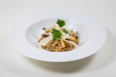 Mantarlı risotto bir beyaz beyaz bir kase içinde Parmesan ile