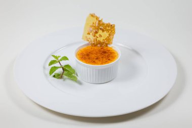 bir beyaz beyaz tabakta Creme brulee ve karamel pul