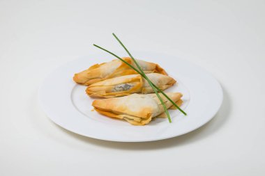 Beyaz bir arka plan üzerinde beyaz bir tabakta samosa