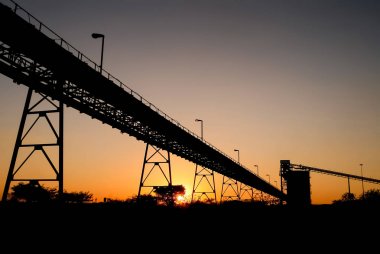 Gün batımı siluet manzara madencilik ve işleme cevheri, cevher zengin rock depolama siloları için taşıma Konveyör bant