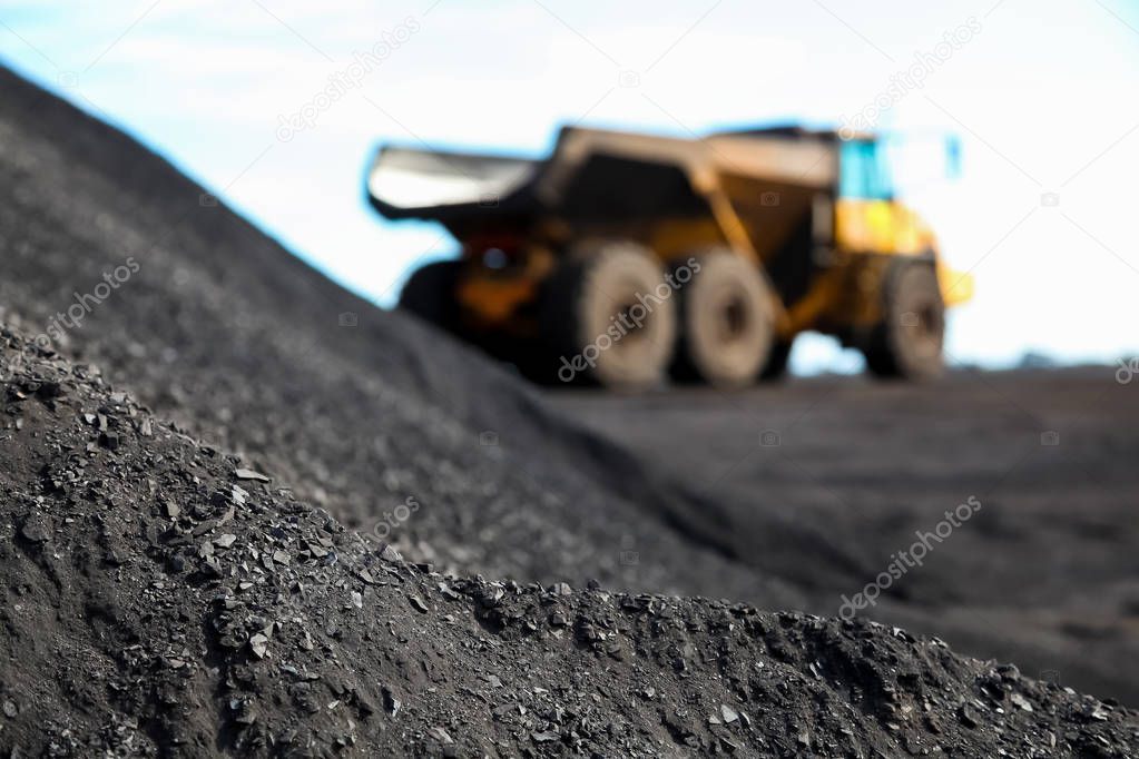 Close up of Manganese dust with a Mining Rock Dump Truck transporting Manganese ore for processing out of focus in the background
