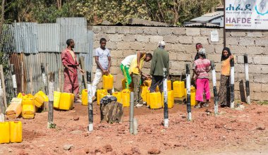 Addis Ababa, Etiyopya, 30 Ocak 2014, erkek ve kadın bir topluluk suyu çıkışı, varil dolduruyor