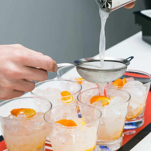 Barman making a old fashioned cocktail in a short glass