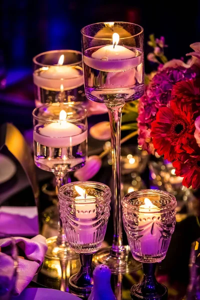 Purple and red decor with candles and lamps for corporate event or gala dinner
