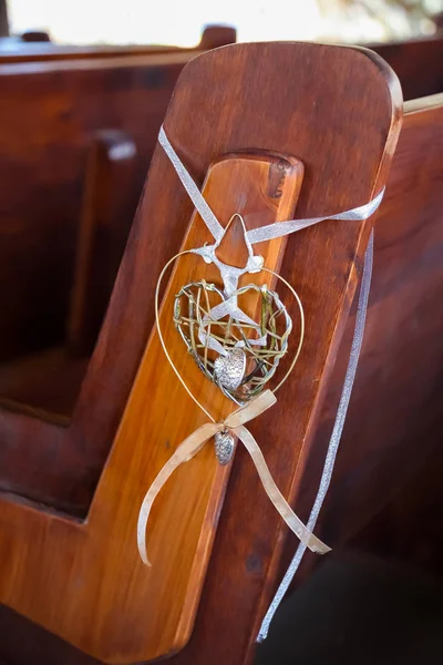Wedding decor church elements, Small wire and ribbon heart decorations on church pew for wedding