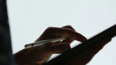 Siluet grafik tasarımcı dijital tablete stylus kalem ile omuz görünümü üzerinde çizim.