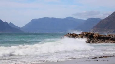 Long Beach 'te kıyıya vuran dalgalar Hout Bay Cape Town' a bakıyor.