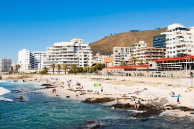 Köpekli çeşitli insanlar ve çocuklar Se 'de dalgalarda oynuyor.