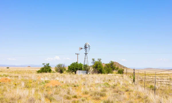 Molino de viento en una granja en la zona de pastizales rurales de Sudáfrica — Foto de Stock