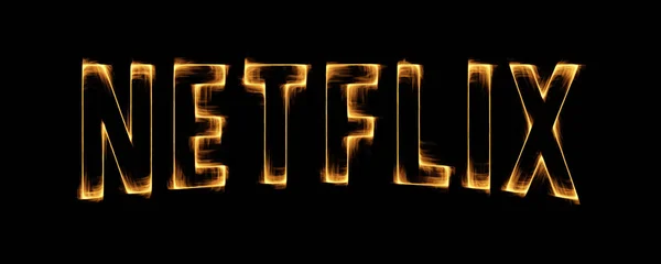 Effet de flammes brûlantes jaunes sur Netflix Icon Logo contre noir — Photo