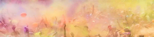 Crowd throwing bright colored powder paint in the air at Holi Fe — Stock Photo, Image
