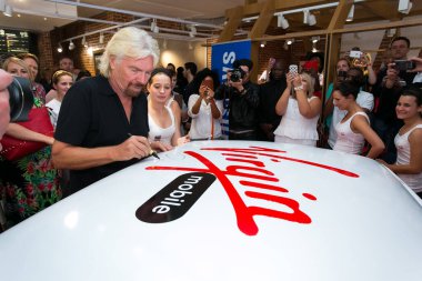 Johannesburg, Güney Afrika - 02 Ekim 2013: Richard Branson Virgin Mobile Guinness Dünya Rekor Girişimi 'nde imza dağıtıyor ve 25 kişiyi düzenli olarak 1970' lerin Mini Cooper 'ına sığdırmayı başardı.