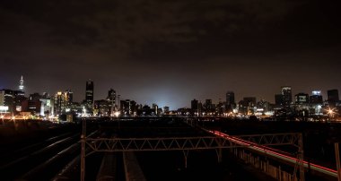 Johannesburg, Güney Afrika - 26 Mart 2011: Braamfontein Johannesburg CBD 'deki Nelson Mandela Köprüsü altındaki banliyö trenlerinin gece görüntüsü