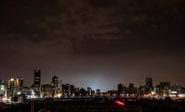 Johannesburg, Güney Afrika - 26 Mart 2011: Braamfontein Johannesburg CBD 'deki Nelson Mandela Köprüsü altındaki banliyö trenlerinin gece görüntüsü