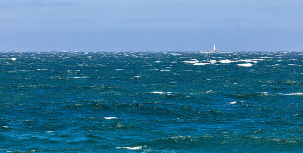Roman Rock lighthouse in False Bay, Cape Town, on a windy rough seas day