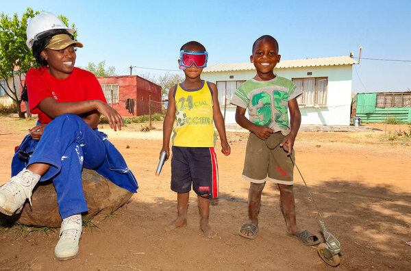 Соуэто, Южная Африка - 7 сентября 2011 года: Два молодых африканских мальчика позируют для фотографии со своими игрушками на улице Соуэто
