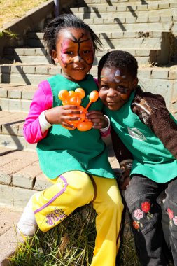 Soweto, Güney Afrika - 18 Temmuz 2012: Genç Afrikalı anaokulu çocukları oyun alanında hayvan balonlarıyla oynuyorlar 