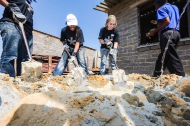 Soweto, Güney Afrika - 05 Eylül 2009: Çeşitli Toplum Yardım Programı, küçük, ekonomik bir ev inşa etmek için çimentoyu karıştırıyor
