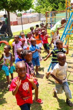 Soweto, Güney Afrika - 16 Kasım 2012: Bir anaokulunun oyun parkında oynayan Afrikalı genç çocuklar 