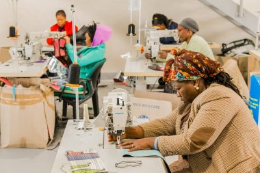 Johannesburg, Güney Afrika - 2 Mayıs 2017: Afrikalı kadın terziler dikiş makinesinde el yapımı giysiler üzerinde çalışıyorlar 