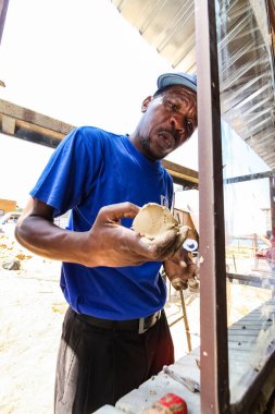 Soweto, Güney Afrika - 05 Eylül 2009: Afrikalı müteahhit, yerel bir kasabada küçük, ekonomik bir ev inşa etmek için bir Toplum Yardım Programı 'na pencere kuruyor