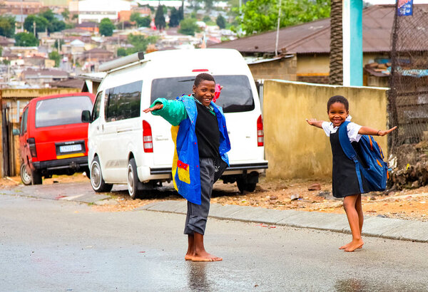 Johannesburg, South Africa - January 17, 2011: African school kids playing on a main road in Alexandra township, a formal and informal settlement 