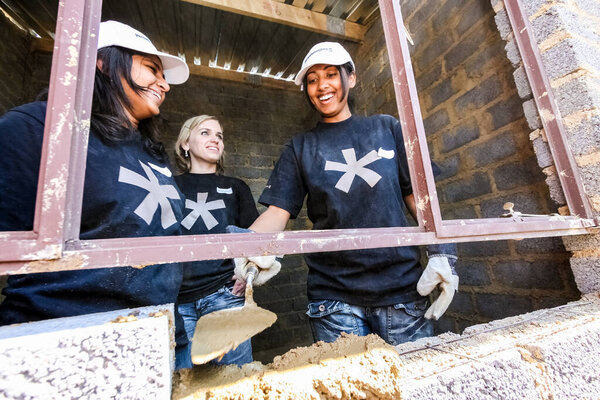 Совето, ЮАР - 05 сентября 2009 года: Разнообразная программа по работе с населением, помогающая построить оконную раму на небольшом недорогом доме в местном игрушечном кораблике.
