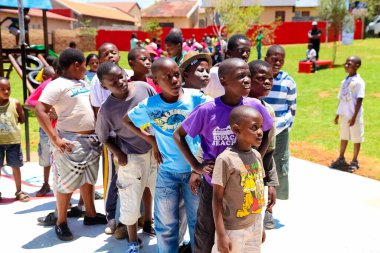 Soweto, Güney Afrika - 11 Aralık 2010: Afrikalı çocuklar halka açık oyun sahasında atış yapmak için sırayla sıraya giriyorlar
