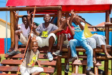 Soweto, Güney Afrika - 11 Aralık 2010: Orman Spor Salonu 'nda oynayan Afrikalı çocuklar ve yerel halk parkındaki diğer park ekipmanları