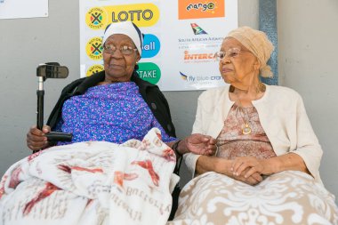 Soweto, Güney Afrika - 1 Aralık 2016: Yerel süpermarket önünde birlikte oturan bir grup yaşlı Afrikalı kadın