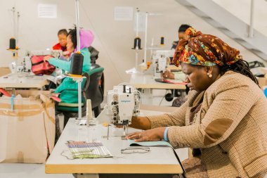 Johannesburg, Güney Afrika - 2 Mayıs 2017: Afrikalı kadın terziler el yapımı giysiler üzerinde dikiş makinesi kullanıyorlardı 