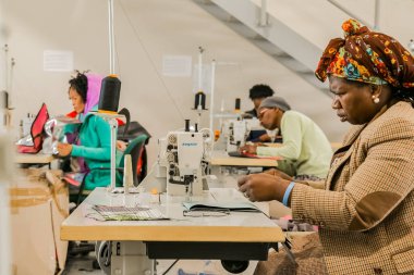 Johannesburg, Güney Afrika - 2 Mayıs 2017: Afrikalı kadın terziler dikiş makinesinde el yapımı giysiler üzerinde çalışıyorlar 