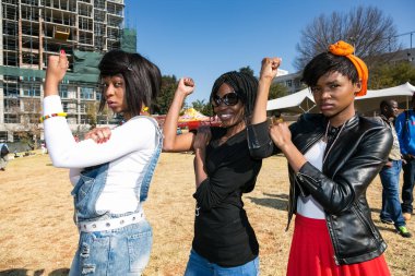 Johannesburg, Güney Afrika - 13 Haziran 2015: Bir grup genç Afrikalı kız feminist güç gösterisi için kol kaslarını esnetiyorlar