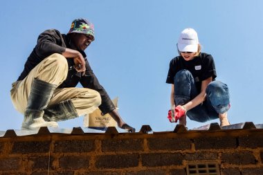 Soweto, Güney Afrika - 05 Eylül 2009: Çeşitli Toplum Yardım Programı yerel bir kasabada küçük ve ekonomik bir eve metal çatı kurulmasına yardımcı oluyor
