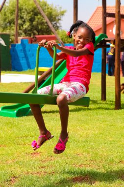 Soweto, Güney Afrika - 11 Aralık 2010: Seesaw 'da oynayan Afrikalı çocuklar ve yerel halk parkındaki diğer park ekipmanları