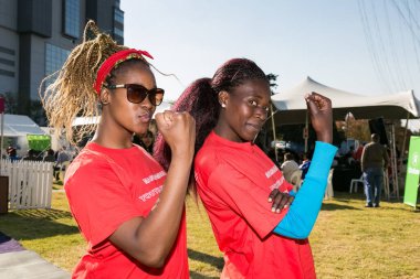 Johannesburg, Güney Afrika - 13 Haziran 2015: Bir grup genç Afrikalı kız feminist güç gösterisi için kol kaslarını esnetiyorlar