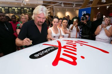 Johannesburg, Güney Afrika - 02 Ekim 2013: Richard Branson Virgin Mobile Guinness Dünya Rekor Girişimi 'nde imza dağıtıyor ve 25 kişiyi düzenli olarak 1970' lerin Mini Cooper 'ına sığdırmayı başardı.