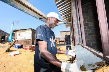 Soweto, Güney Afrika - 05 Eylül 2009: Yerel bir kasabada küçük, ekonomik bir eve pencere çerçevesi yapılmasına yardımcı olan Toplum Yardım Programı