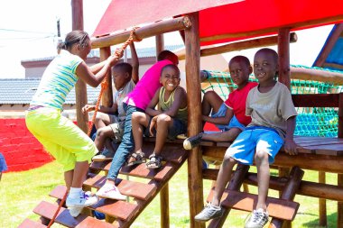 Soweto, Güney Afrika - 11 Aralık 2010: Orman Spor Salonu 'nda oynayan Afrikalı çocuklar ve yerel halk parkındaki diğer park ekipmanları