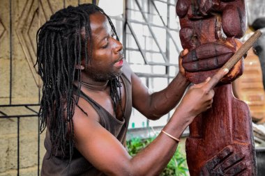 Johannesburg, Güney Afrika - 17 Ocak 2011: Afrikalı heykeltıraş tahtadan geleneksel bir heykel oyuyor
