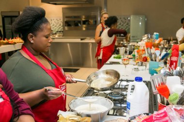 Johannesburg, Güney Afrika - 05 Ekim 2017: Genç Afrikalı kadınlar yemek pişirme ve pişirme kursunda öğreniyor