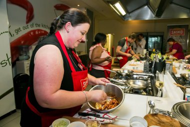Johannesburg, Güney Afrika - 10 Kasım 2016: Yemek pişirme ve pişirme kursunda yemek yapmayı öğrenen genç kadınlar