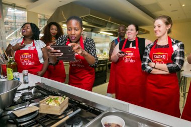 Johannesburg, Güney Afrika - 10 Kasım 2016: Çeşitli genç kadınlar yemek pişirme ve pişirme kursunda öğreniyor
