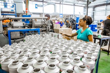 Johannesburg, Güney Afrika - 19 Ekim 2012: Yapıştırıcı fabrikasında üretim bandı üzerinde çalışan çeşitli insanlar