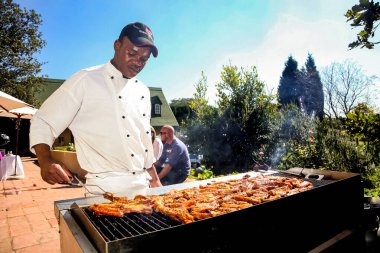 Johannesburg, Güney Afrika - 21 Mayıs 2011: Afrikalı adam açık hava etkinliğinde barbekü ızgarasında çalışıyor