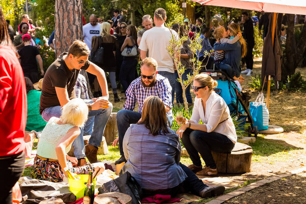 Йоханнесбург, ЮАР - 24 мая 2015 г.: толпы людей, сидящих в пивном саду на открытом фермерском рынке 