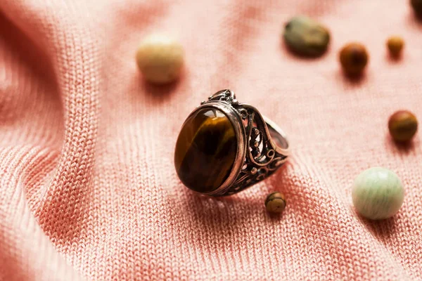 古いヴィンテージのおばあちゃんのリングと Tiger Eye 宝石ピンクの生地の背景 — ストック写真