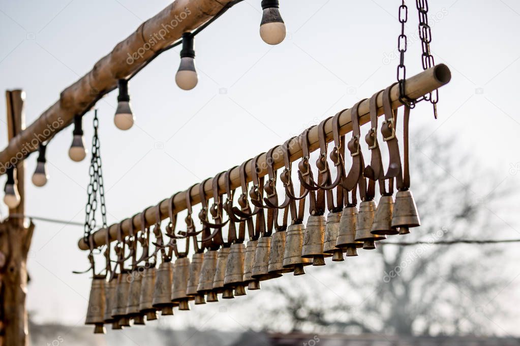 Traditional ritual brass bells hanging outside in a row