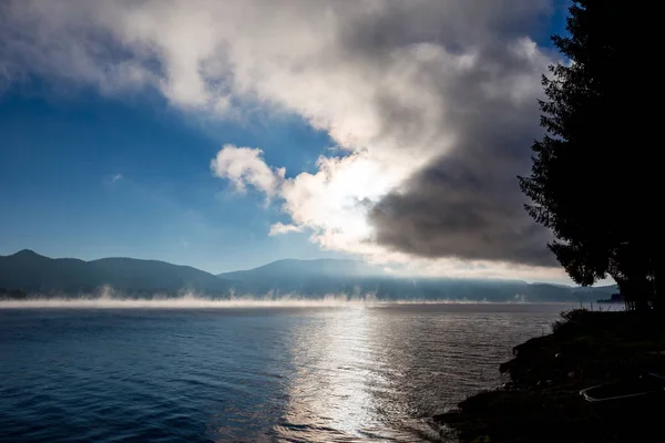 Sol saliendo de las nubes con evaporación de agua — Foto de Stock