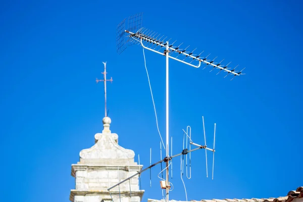 Стара біла телевізійна антена на даху з блакитним небом — стокове фото